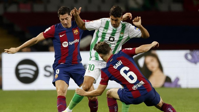 Betis Ayoze Perez fights for the ball with Barcelonas Gavi and Robert Lewandowski during a Spanish La Liga soccer match between Barcelona and Betis at the Olympic Stadium of Montjuic in Barcelona, Spain, Saturday, Sept. 16, 2023. (AP Photo/Joan Monfort)