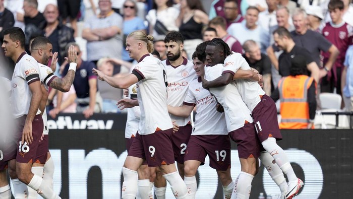 Manchester Citys Jeremy Doku, right, celebrates after scoring his sides first goal during the English Premier League soccer match between West Ham United and Manchester City at London stadium in London, Saturday, Sept. 16, 2023. (AP Photo/Kin Cheung)