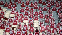 Sebagai gantinya, pihak tuan rumah memasang fans buatan yang terbuat dari potongan kardus dengan foto kepala penggemar. Ya, ampun! (Foto: AFP/ATTA KENARE)
