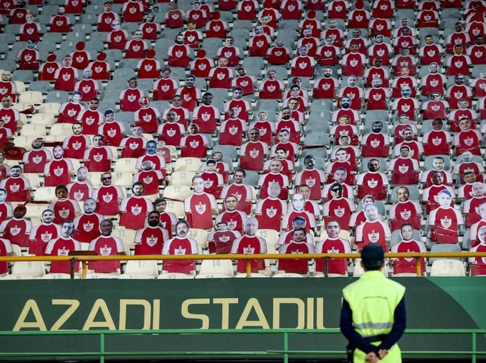 A security man looks at life-size cutouts depicting a crowd of spectators placed in empty seats during the AFC Champions League group E football match between Persepolis FC and al-Nassr FC at Tehran's Azadi stadium, on September 19, 2023. (Photo by ATTA KENARE / AFP)