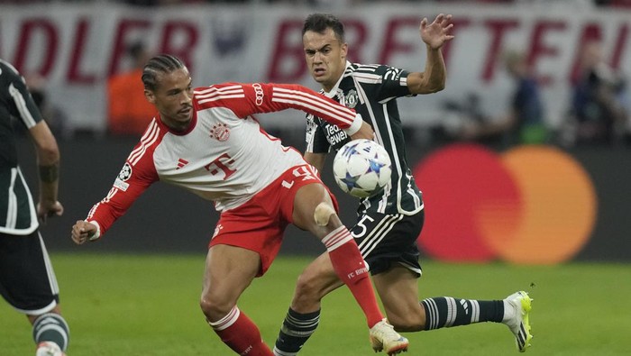 Bayerns Leroy Sane, left, is challenged by Manchester Uniteds Sergio Reguilon during the Champions League group A soccer match between Bayern Munich and Manchester United at the Allianz Arena stadium in Munich, Germany, Wednesday, Sept. 20, 2023. (AP Photo/Matthias Schrader)