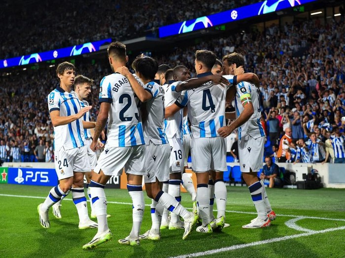 Real Sociedad's Spanish midfielder #23 Brais Mendez celebrates with teammates  after scoring his team's first goal during the UEFA Champions League 1st round day 1 group D football match between Real Sociedad and Inter Milan at the Reale Arena stadium in San Sebastian on September 20, 2023. (Photo by Ander GILLENEA / AFP)
