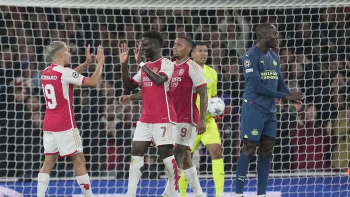 Arsenal's Bukayo Saka, right, celebrates after scoring during their Group B Champion League soccer match, between Arsenal and PSV Eindhoven at the Emirates Stadium in London, Wednesday, Sept. 20, 2023. (AP Photo/Kin Cheung)
