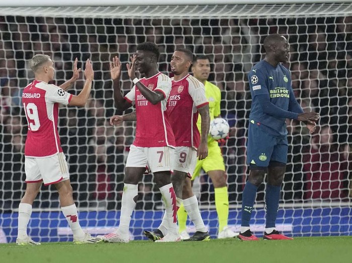 Arsenal's Bukayo Saka, right, celebrates after scoring during their Group B Champion League soccer match, between Arsenal and PSV Eindhoven at the Emirates Stadium in London, Wednesday, Sept. 20, 2023. (AP Photo/Kin Cheung)