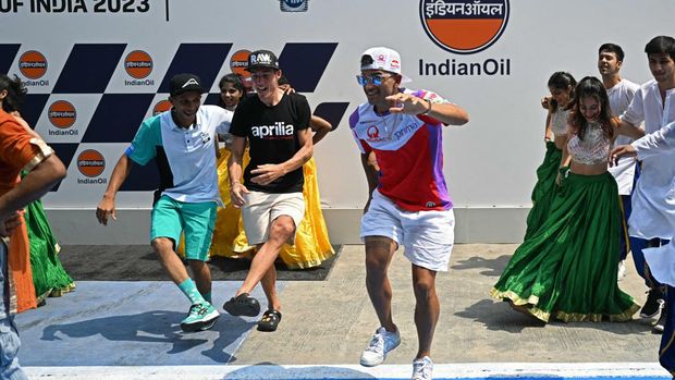 Prima Pramac Racing's Spanish rider Jorge Martin (center R), Aprilia Racing's Spanish rider Aleix Espargaro (C) and Petronas's MIE Racing's Moto3 Indian rider Kadai Yaseen Ahamed (L) dance with Indian performers ahead of the Indian MotoGP Grand Prix at the Buddh International Circuit in Greater Noida on the outskirts of New Delhi, on September 21, 2023. (Photo by Money SHARMA / AFP)