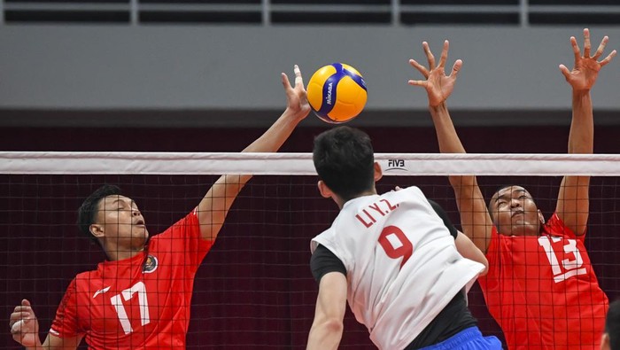 Timnas Voli Indonesia vs China Pebola voli putra Indonesia Hernanda Zulfi (kanan) dan Agil Angga Anggara (kiri) menahan bola spike dari pebola voli China Chuan Jiang (tengah) pada babak 12 besar Asian Games 2022 di Linping Sport Centre Gymnasium, Hangzhou, Zhejiang, China, Jumat (22/9/2023). Indonesia kalah dengan skor 1-3 (17-25,17-25,25-23 dan 22-25). ANTARA FOTO/M Risyal Hidayat/rwa.