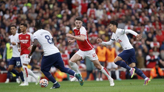 Arsenals Declan Rice, center, is chased by Tottenhams Son Heung-min, right, during the English Premier League soccer match between Arsenal and Tottenham Hotspur at Emirates stadium in London, England, Sunday, Sept. 24, 2023. (AP Photo/David Cliff)