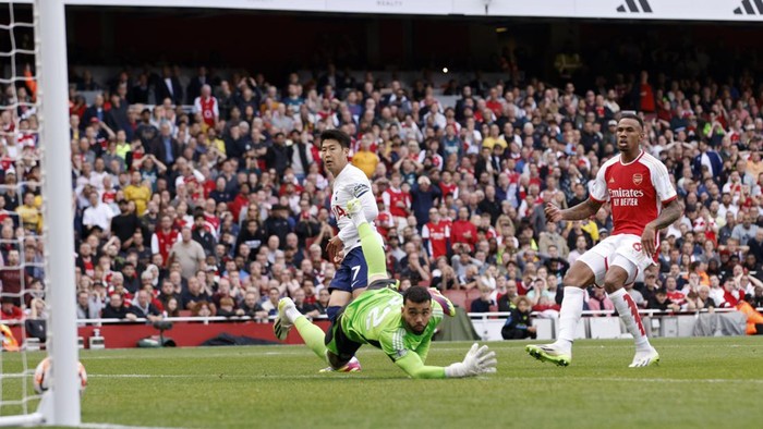 Tottenhams Son Heung-min, left, scores his sides second goal past Arsenals goalkeeper David Raya during the English Premier League soccer match between Arsenal and Tottenham Hotspur at Emirates stadium in London, England, Sunday, Sept. 24, 2023. (AP Photo/David Cliff)