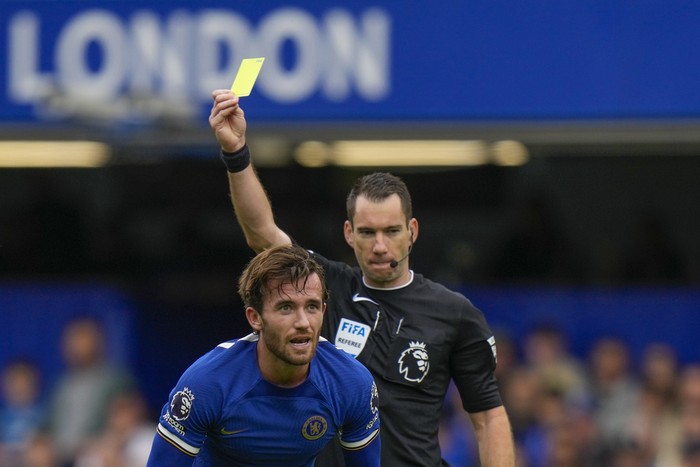 Referee Jarred Gillett shows a yellow card to Chelseas Ben Chilwell during the English Premier League soccer match between Chelsea and Aston Villa at Stamford Bridge stadium in London, Sunday, Sept. 24, 2023. (AP Photo/Alastair Grant)