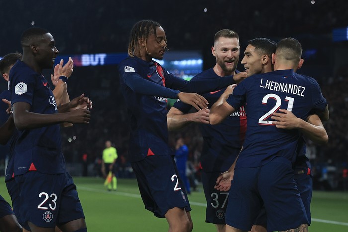 PSG players celebrate with teammate Achraf Hakimi who scored his sides first goal during the French League One soccer match between Paris Saint Germain and Olympique de Marseille at Parc des Princes stadium in Paris, France, Sunday, Sept. 24, 2023. (AP Photo/Aurelien Morissard)