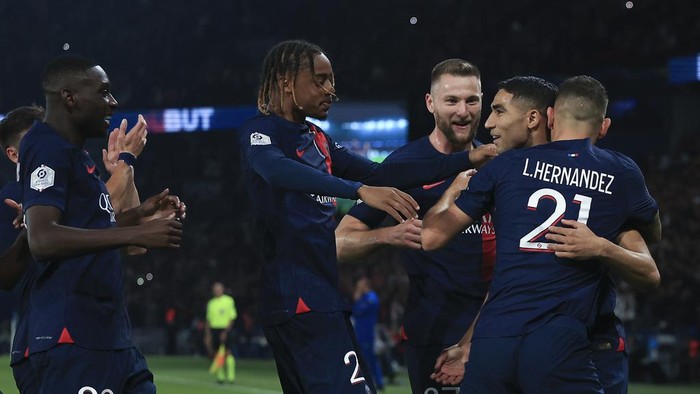 PSG players celebrate with teammate Achraf Hakimi who scored his sides first goal during the French League One soccer match between Paris Saint Germain and Olympique de Marseille at Parc des Princes stadium in Paris, France, Sunday, Sept. 24, 2023. (AP Photo/Aurelien Morissard)