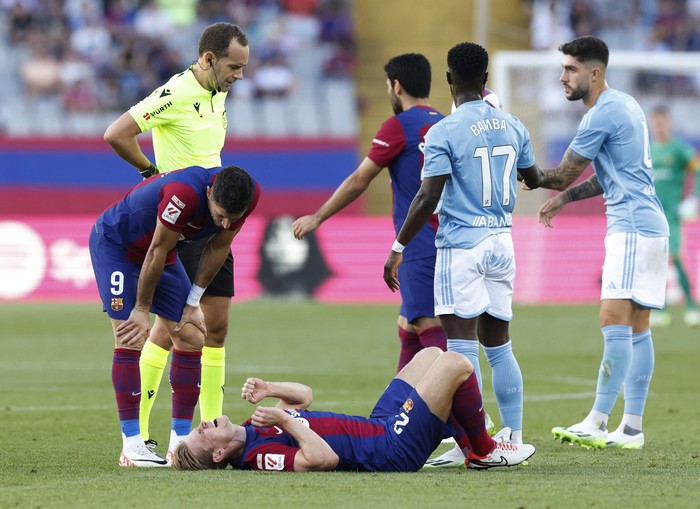 Soccer Football - LaLiga - FC Barcelona v Celta Vigo - Estadi Olimpic Lluis Companys, Barcelona, Spain - September 23, 2023 FC Barcelonas Frenkie de Jong reacts after sustaining an injury as Robert Lewandowski and referee Mario Melero Lopez look on REUTERS/Albert Gea