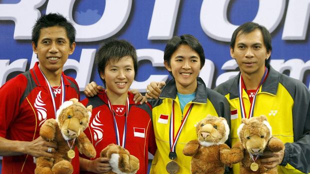 Indonesia's mixed doubles champions Nova Widianto (L) and Lilyana Natsir (2nd L) pose for photos at the winners' podium with compatriots, third-placed Vita Marissa (2nd R) and Flandy Limpele (R), on the final day of the World Badminton Championships in Kuala Lumpur, 19 August 2007. Widianto and Natsir won 21-16, 21-14 against China's Gao Ling and Zheng Bo. AFP PHOTO/TENGKU BAHAR (Photo by TENGKU BAHAR / AFP)