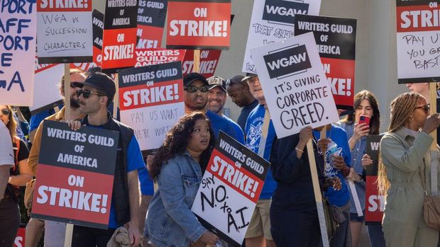 LOS ANGELES, CA - MAY 02: People picket outside of Paramount Pictures on the first day of the Hollywood writers strike on May 2, 2023 in Los Angeles. Scripted TV series, late-night talk shows, film and streaming productions are being interrupted by the Writers Guild of America (WGA) strike. In 2007 and 2008, a WGA strike shut down Hollywood productions for 100 days, costing the local economy between $2 billion and $3 billion. (Photo by David McNew/Getty Images)