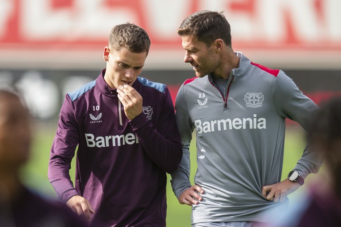 Bayer Leverkusens head coach Xabi Alonso, right, talks to Florian Wirtz, left, during a final training session in Leverkusen, Germany, Wednesday, Sept. 20, 2023. Leverkusen will face BK Hacken for a Europa League group H soccer match in Leverkusen on Sept. 21, 2023. (Marius Becker/dpa via AP)