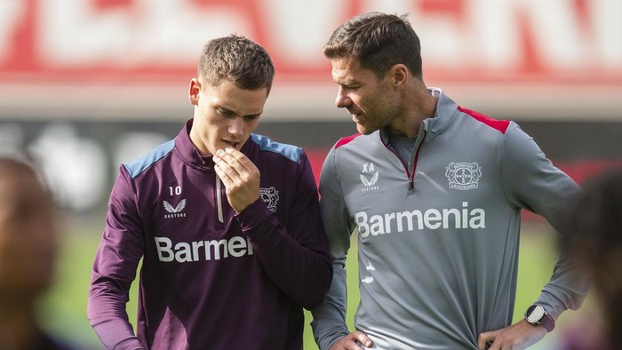 Bayer Leverkusens head coach Xabi Alonso, right, talks to Florian Wirtz, left, during a final training session in Leverkusen, Germany, Wednesday, Sept. 20, 2023. Leverkusen will face BK Hacken for a Europa League group H soccer match in Leverkusen on Sept. 21, 2023. (Marius Becker/dpa via AP)