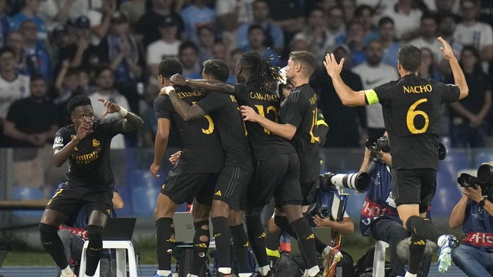 Real Madrids Jude Bellingham celebrates with teammates after scoring his sides second goal during the Champions League group C soccer match between Napoli and Real Madrid at the Diego Armando Maradona stadium in Naples, Italy, Tuesday, Oct. 3, 2023. (AP Photo/Alessandra Tarantino)