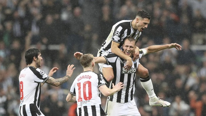 Newcastles Dan Burn, bottom right, celebrates with teammates after scoring his sides second goalduring the Champions League group F soccer match between Newcastle and Paris Saint Germain at St. James Park, Wednesday, Oct. 4, 2023, in Newcastle, England. (AP Photo/Scott Heppell)
