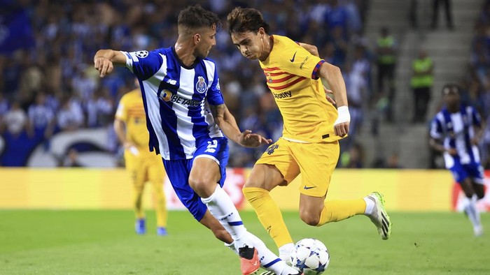 Barcelonas Joao Felix tries to drive the ball past Portos Fabio Cardoso, left, during a Champions League group H soccer match between FC Porto and Barcelona at the Dragao stadium in Porto, Portugal, Wednesday, Oct. 4, 2023. (AP Photo/Luis Vieira)