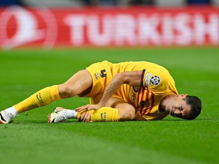 Barcelona's Polish forward #09 Robert Lewandowski lies on the pitch after a fall during the UEFA Champions League 1st round day 2 group H football match between FC Porto and FC Barcelona at the Dragao stadium in Porto on October 4, 2023. (Photo by Patricia DE MELO MOREIRA / AFP)