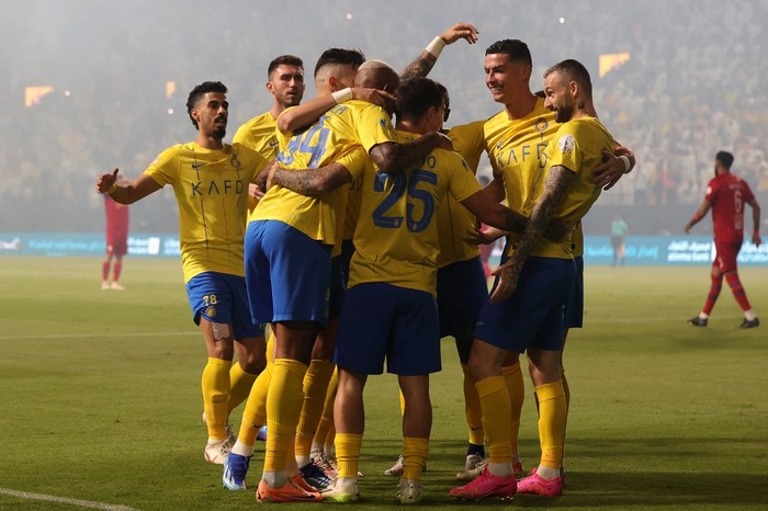 Nassrs Portuguese midfielder #25 Otavio celebrates with teammates after scoring the first goal during the Saudi Pro League football match between Al-Nassr and Abha at the King Saud University Stadium in Riyadh on October 6, 2023. (Photo by Fayez Nureldine / AFP)