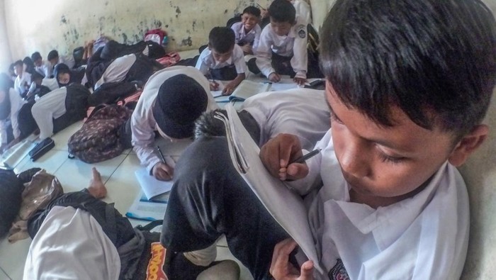 Sejumlah siswa kelas IV SDN Cidokom 02 mengikuti kegiatan belajar di lantai ruangan musholla di Rumpin, Kabupaten Bogor, Jawa Barat , Jumat (6/10/2023). Kegiatan belajar mengajar (KBM) dengan kondisi tanpa meja kursi di sekolah tersebut sudah berlangsung lebih dari dua tahun karena kekurangan ruangan kelas sehingga ruang laboratorium dan musholla digunakan sebagai kelas untuk menampung total 494 siswa. ANTARA FOTO/Yulius Satria Wijaya/nym.