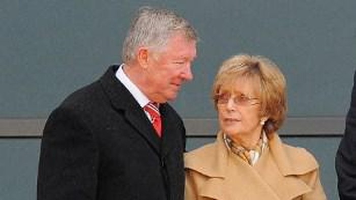 Manchester United manager Sir Alex Ferguson (L) speaks to his wife Cathy before the unveiling of a statue of him at Old Trafford in Manchester, north-west England on November 23, 2012.  The statue, made in bronze and standing some nine feet  (2.74 metres) was unveiled in a ceremony attended by fans, players and former players including Eric Cantona and Ruud van Nistelrooy.   AFP PHOTO/ ANDREW YATES (Photo by ANDREW YATES / AFP)
