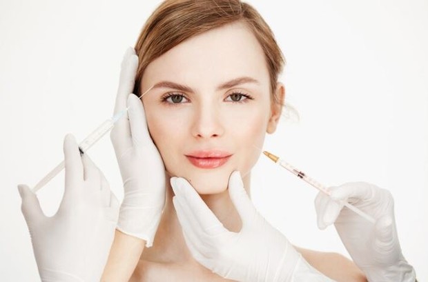 Perempuan dengan peralatan bedah kosmetik di sekitar wajahnya