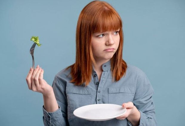 Melewatkan waktu makan/ foto: Freepik/ freepik Perempuan memegang piring dan garpu