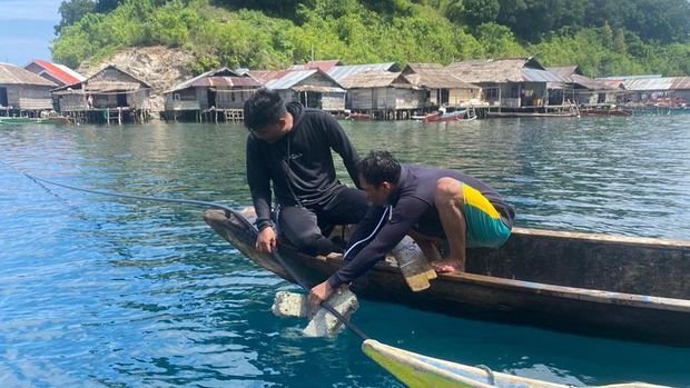 Sertu Faldi Canu memasang aliran air bersih bersama warga Pulau Enam, Tojo Una-una
