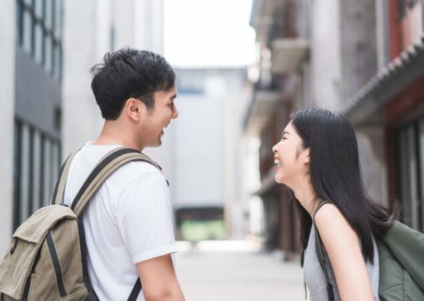 Pasangan sedang berhadap-hadapan sambil tersenyum