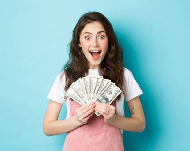 Perempuan sedang memegang berlembar-lembar uang