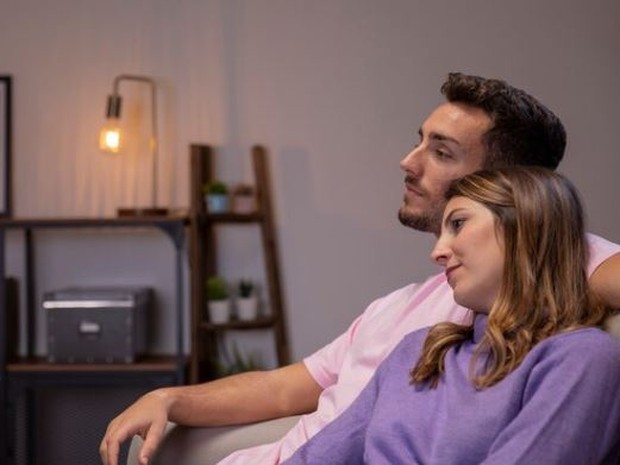 Pasangan sedang duduk bersantai saling bersandar