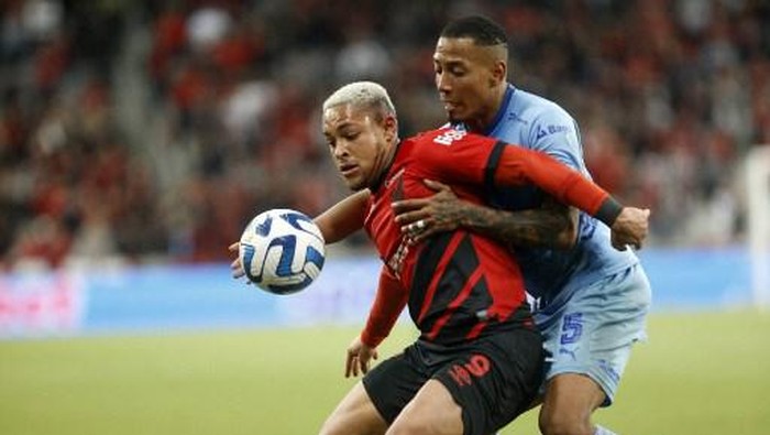 Athletico Paranaenses forward Vitor Roque (L) and Bolivars defender Jairo Quinteros fight for the ball during the Copa Libertadores round of 16 second leg football match between Brazils Athletico Paranaense and Bolivias Bolivar at Ligga Arena in Curitiba, Brazil, on August 8, 2023. (Photo by Albari Rosa / AFP)