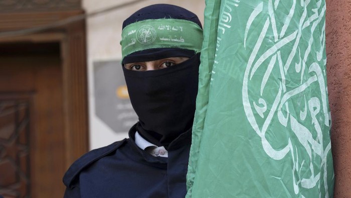 Potret Brigade Al Qassam, Pasukan Khusus Hamas yang Tembus Israel Masked militant from the Izzedine al-Qassam Brigades, the military wing of Hamas, waves the green flag of the Islamist group during a protest in support of Palestinian prisoners in Israeli jails, after Friday prayer in Nusseirat refugee camp, central Gaza Strip, Friday, Aug. 18, 2023. A thousand prisoners in Israeli jails started a mass hunger strike Friday in protest over harsh new Israeli prison measures. (AP Photo/Adel Hana)