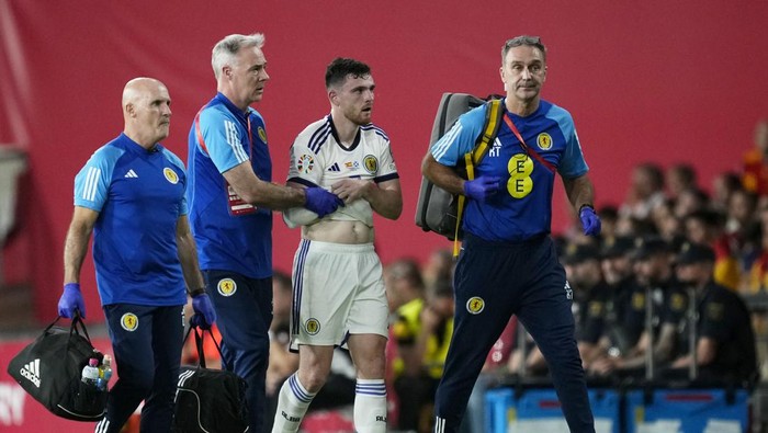 Scotlands Andrew Robertson leaves the pitch holding his arm following a collision with Spain goalkeeper Unai Simon during the Euro 2024 group A qualifying soccer match between Spain and Scotland at La Cartuja stadium in Seville, Spain, Thursday, Oct. 12, 2023. (AP Photo/Jose Breton)