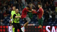 Ini adalah momen si penyusup lapangan menghampiri Ronaldo. Foto: REUTERS/PEDRO NUNES