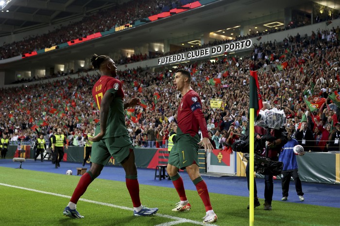 cristiano ronaldo timnas portugal portugal vs slovakia kualifikasi piala eropa 2024 kualifikasi euro 2024 Portugal's Cristiano Ronaldo celebrates with Rafael Leao, left, after scoring his side's second goal from the penalty spot during the Euro 2024 group J qualifying soccer match between Portugal and Slovakia at the Dragao stadium in Porto, Portugal, Friday, Oct. 13, 2023. (AP Photo/Luis Vieira)