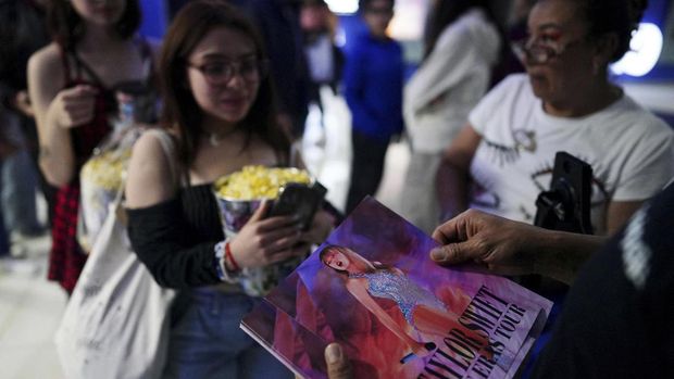 Fans receive a photograph of Taylor Swift as they enter a cinema to watch Taylor Swift's Eras Tour concert movie in Mexico City, Mexico October 13, 2023. REUTERS/Alexandre Meneghini