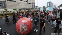 Masyarakat menyaksikan bola raksasa dari sarinah ke Bundaran HI saat Car Free Day di kawasan Jalan Thamrin, Jakarta, Minggu (15/10/2023).