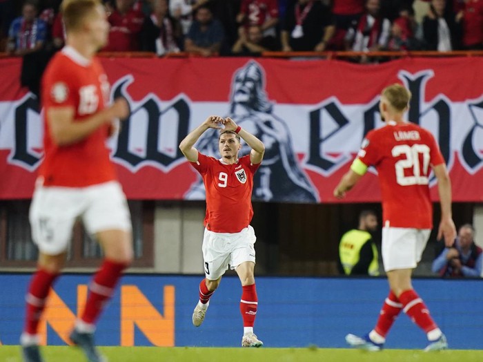 Austria's Marcel Sabitzer, centre, celebrates after scoring his side's second goal during the Euro 2024 group F qualifying soccer match between Austria and Belgium at the Ernst Happel stadium in Vienna, Austria, Friday, Oct. 13, 2023. (AP Photo/Florian Schroetter)