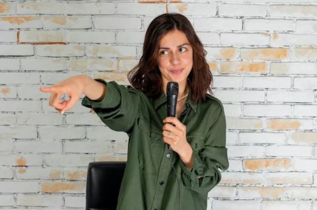 Perempuan memegang mic sambil menunjuk