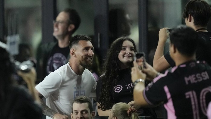Inter Miami forward Lionel Messi, left, poses for pictures with fans after an MLS soccer match between Inter Miami and Charlotte FC, Wednesday, Oct. 18, 2023, in Fort Lauderdale, Fla. (AP Photo/Rebecca Blackwell)