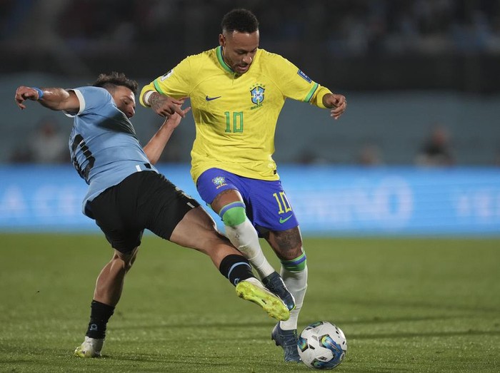 Brazil's Neymar, right, and Uruguay's Manuel Ugarte battle for the ball during a qualifying soccer match for the FIFA World Cup 2026 at Centenario stadium in Montevideo, Uruguay, Tuesday, Oct. 17, 2023. (AP Photo/Matilde Campodonico)