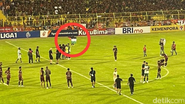 Pemain PSM Makassar Rezky Eka membentangkan bendera Palestina di lapangan.