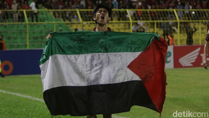 Pemain PSM Makassar Rizky Eka Pratama selebrasi gol membentangkan bendera Palestina pada laga melawan Arema FC di Stadion Gelora BJ Habibie, Parepare.