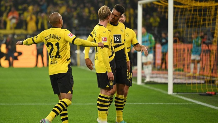 Dortmunds German midfielder #19 Julian Brandt (2nd L) celebrates scoring the opening goal with his teammates during the German first division Bundesliga football match between BVB Borussia Dortmund and SV Werder Bremen in Dortmund, western Germany on October 20, 2023. (Photo by INA FASSBENDER / AFP) / DFL REGULATIONS PROHIBIT ANY USE OF PHOTOGRAPHS AS IMAGE SEQUENCES AND/OR QUASI-VIDEO