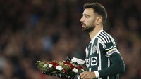 Sebelumnya, kapten MU Bruno Fernandes membawa karangan bunga untuk ditaruh di tengah lapangan sebelum laga. Foto: REUTERS/ED SYKES