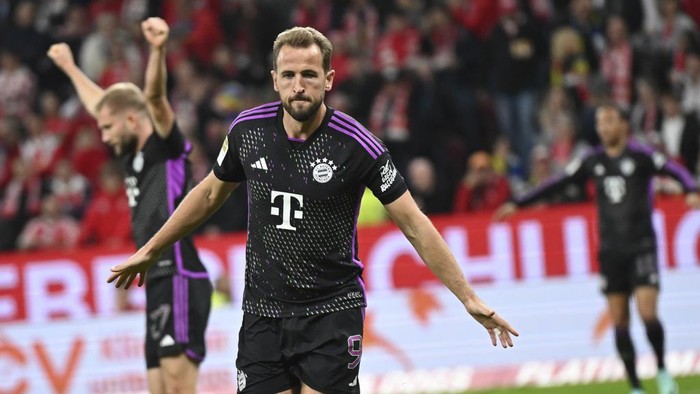 Munichs Harry Kane celebrates after scoring his teams second goal during the Bundesliga soccer match between Mainz 05 and Bayern Munich at Mewa Arena in Mainz, Germany, Saturday, Oct. 21, 2023. (Arne Dedert/dpa via AP)