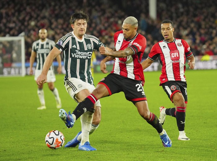 Manchester Uniteds Harry Maguire challenges for the ball with Sheffield Uniteds Vinicius Souza during the English Premier League soccer match between Sheffield United and Manchester United at Bramall Lane in Sheffield, England, Saturday, Oct. 21, 2023. (AP Photo/Jon Super)